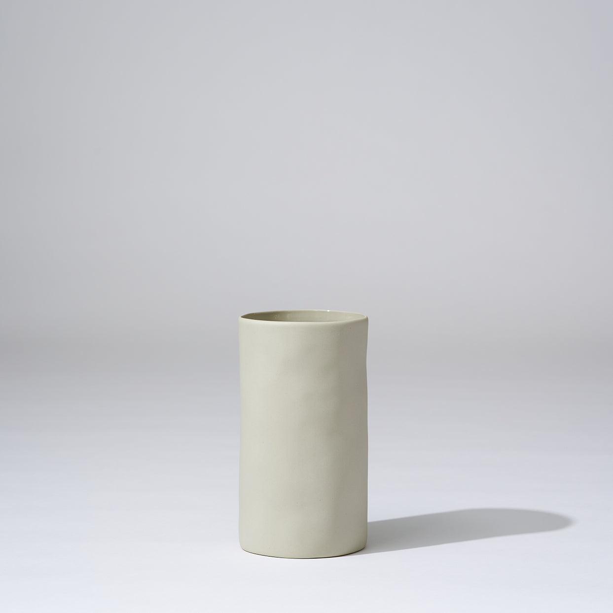 Beige ceramic vase on a light gray background