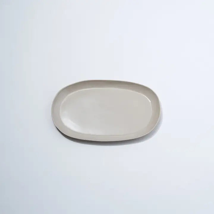 Beige ceramic oval plate on a light gray background