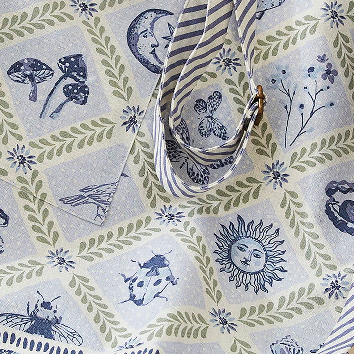 Decorative fabric with nature-themed patterns including mushrooms, flowers, and celestial elements.