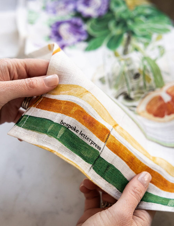 A close up of Linen tea towel with flowers a cockatiel on it 