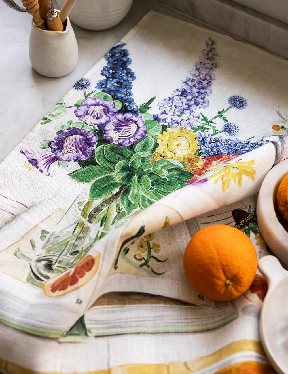 Linen tea towel with flowers a cockatiel on it and an orange 