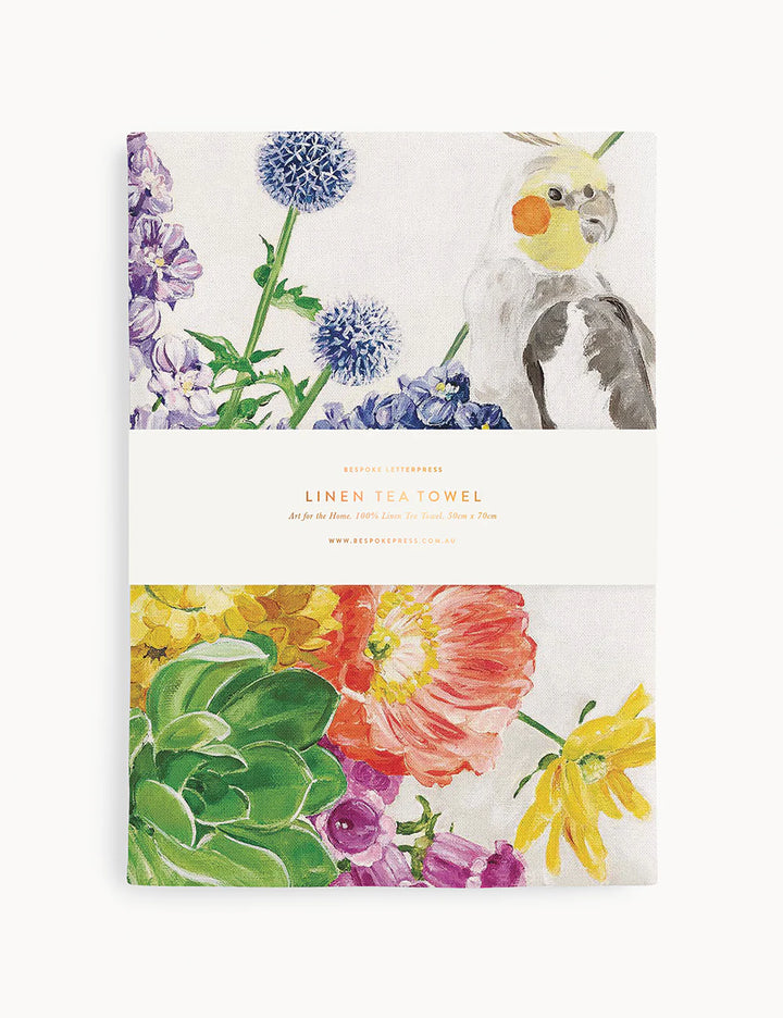 Linen tea towel with flowers a cockatiel on it on a white background
