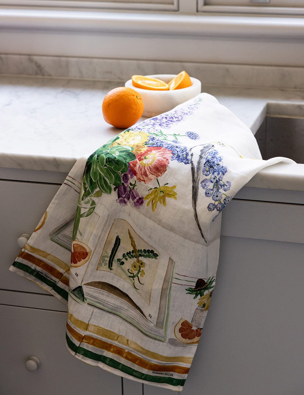Linen tea towel with flowers a cockatiel on it on a kitchen sink