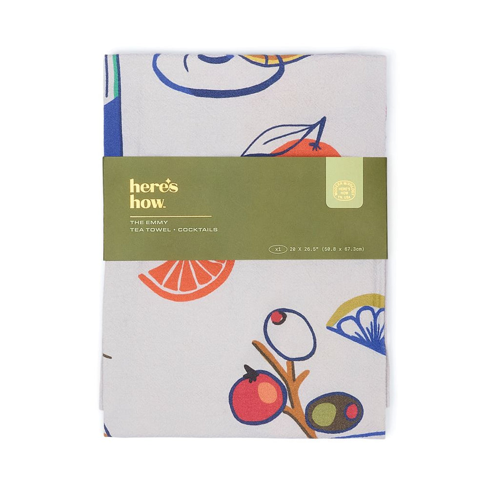 Tea towel with fruit design and 'here's how' branding on a white background