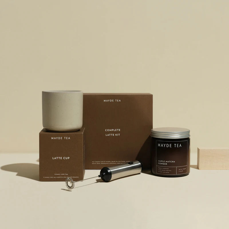 Mayde Tea latte kit with latte cup, milk container, and packaging on a beige background