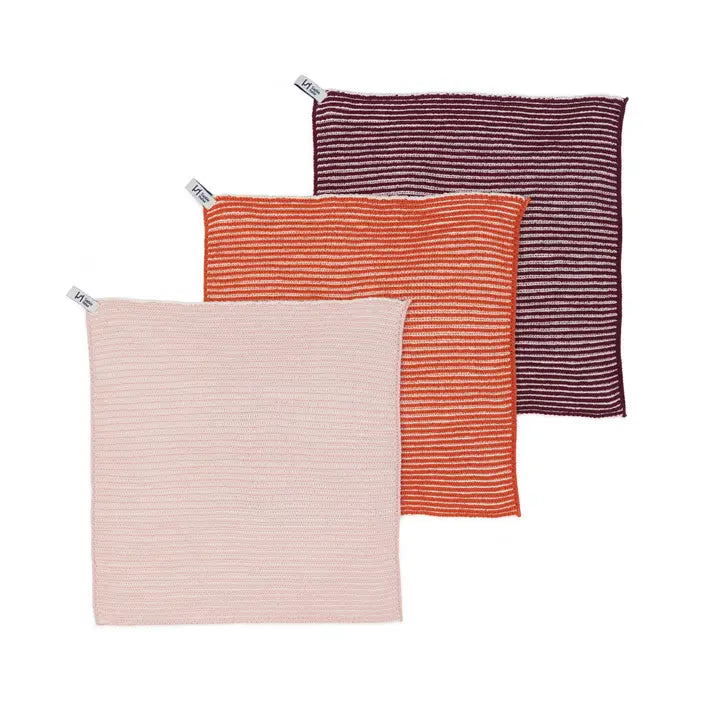 Three striped cotton dish cloths in pink, orange, and purple on a white background