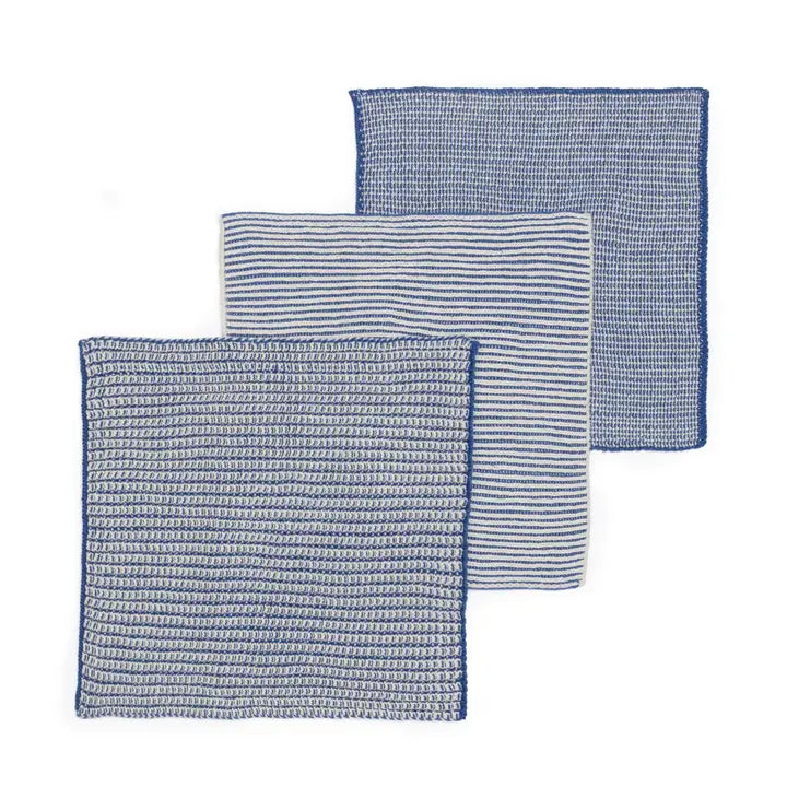 Set of four blue and white patterned dish cloths on a white background