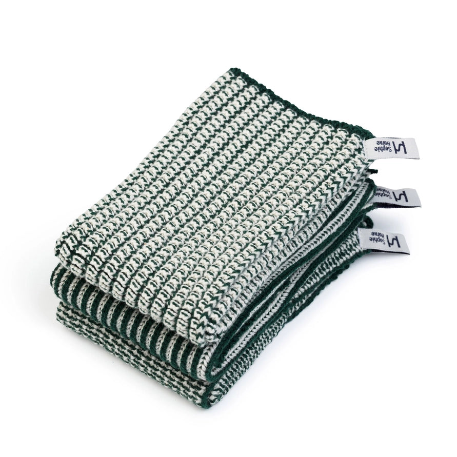 Stack of green and white textured dishcloths with labels on a white background