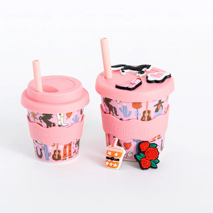 Two pink cups with colorful designs and straws on a white background