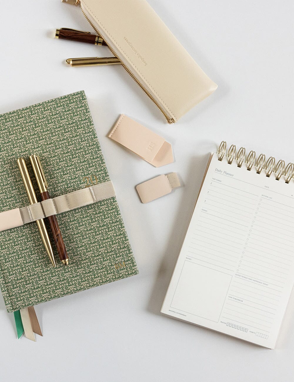 Notebooks, pens, and sticky notes on a white surface