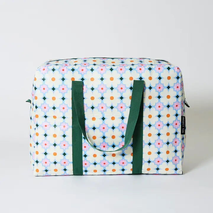 Patterned bag with green handles on a light gray background