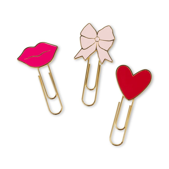 Three decorative paperclips with a pink lip, bow, and red heart design on a white background.