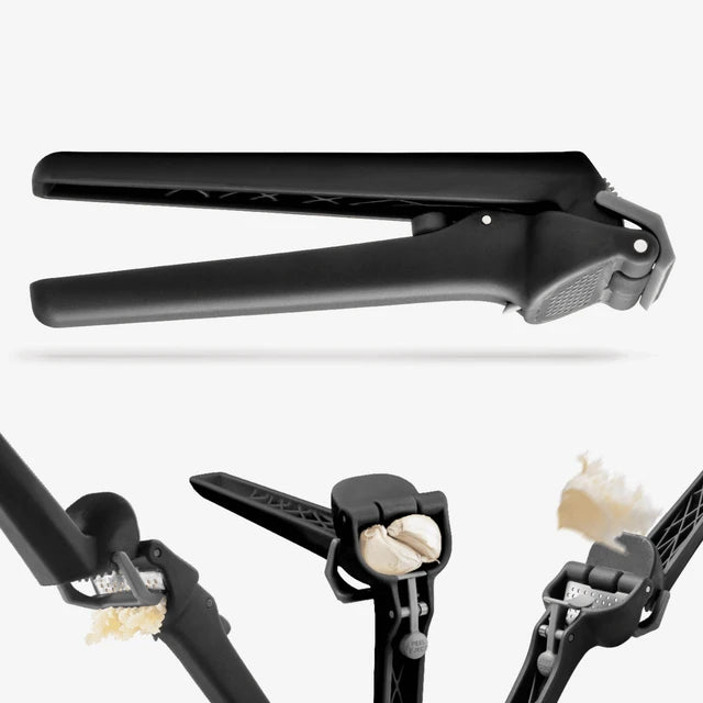 Black garlic press with garlic cloves on a white background