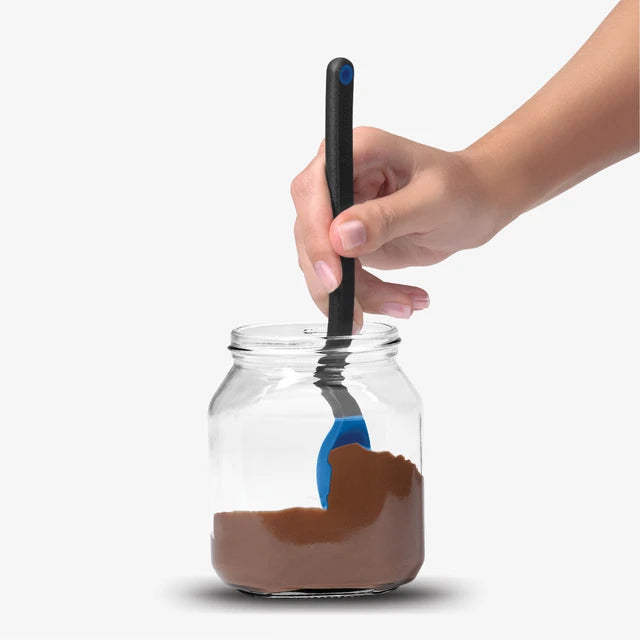 Hand using a spoon to scoop chocolate spread from a jar on a white background