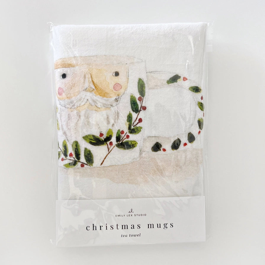 Packaged tea towel with Christmas design featuring a Santa Claus face and holly leaves on a white background.