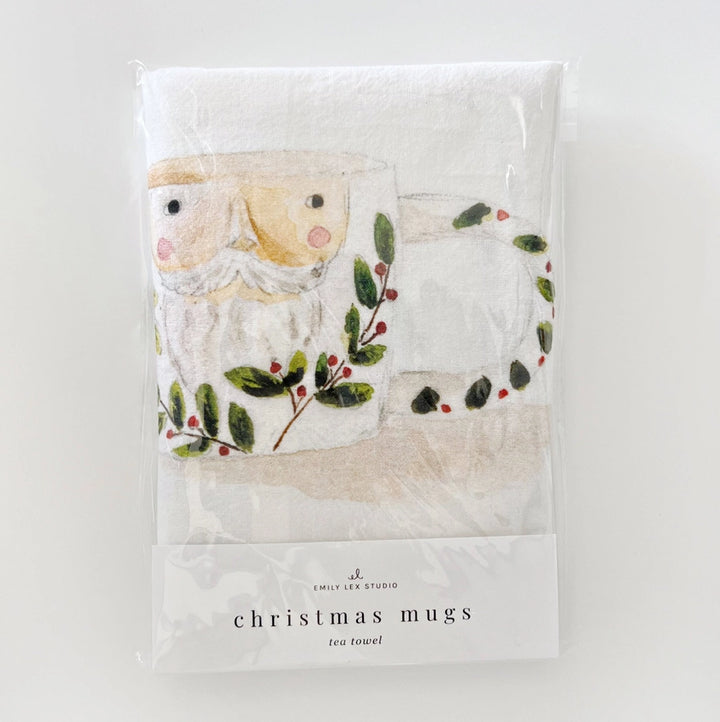 Packaged tea towel with Christmas design featuring a Santa Claus face and holly leaves on a white background.