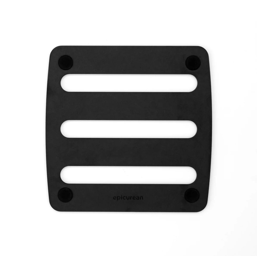 Black wooden trivet with three horizontal slots on a white background, featuring the brand &