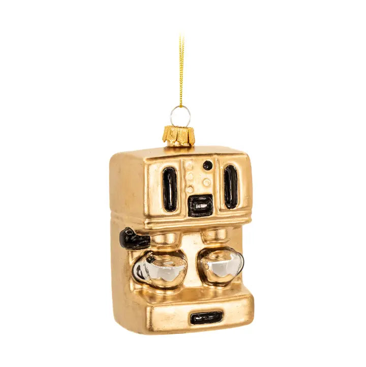 A gold-colored coffee machine Christmas ornament with black details, two clear glass cups, and a gold hanging string, shown against a plain white background.