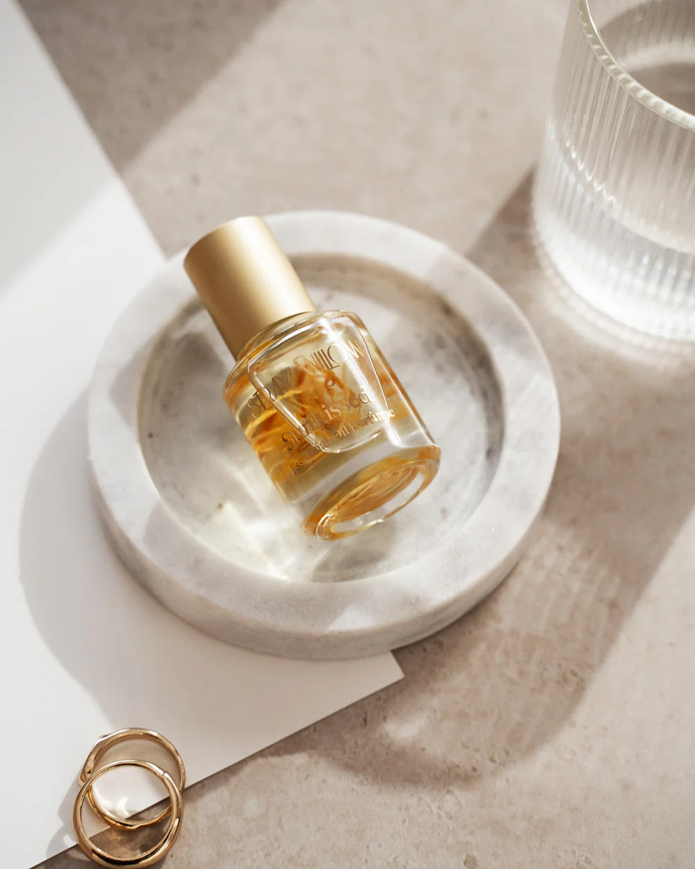 Small clear bottle with gold cap on a marble surface