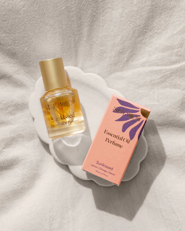Sunkissed essential oil perfume bottle and packaging on a light fabric background