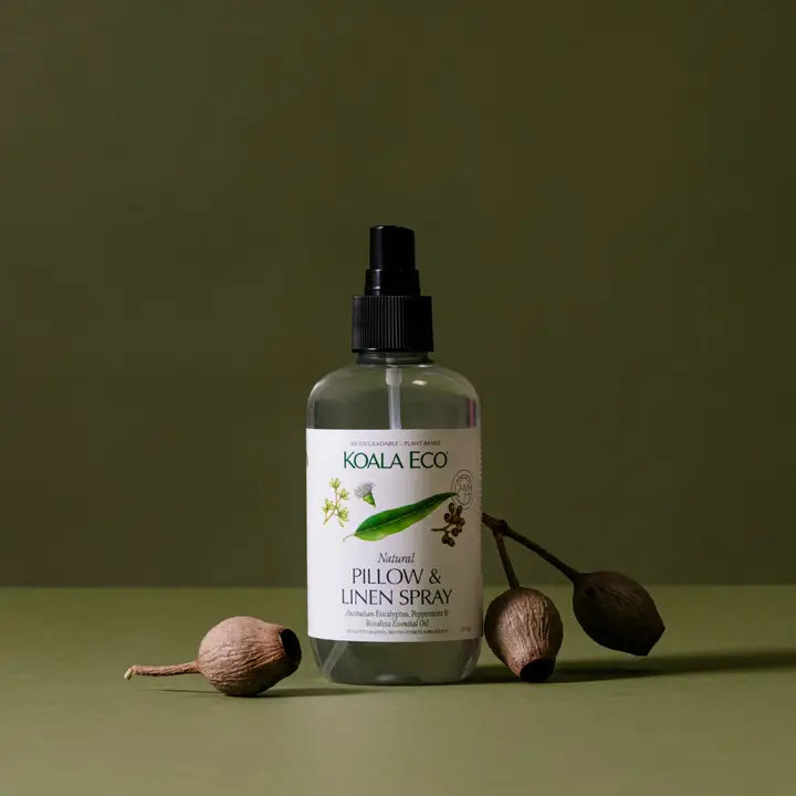 Koala Eco pillow and linen spray bottle with natural elements on a green background