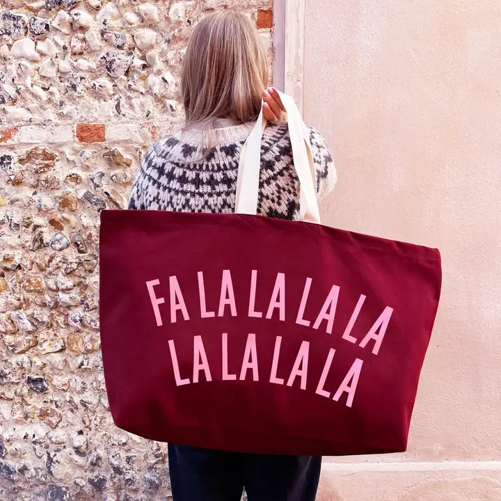 Person holding a red tote bag with &