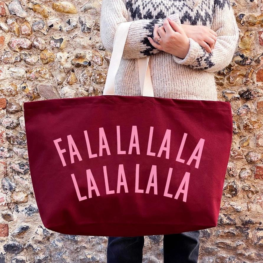 Person holding a red tote bag with &
