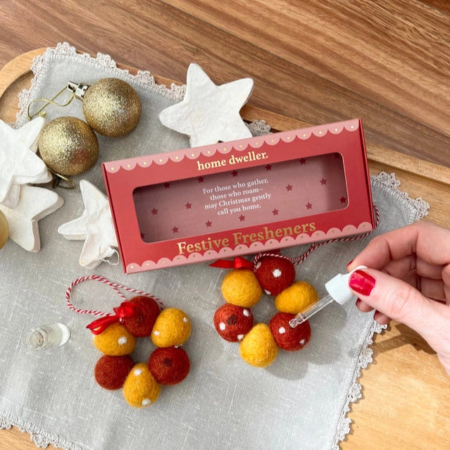 Festive fresheners with a 'home dweller' box on a wooden surface.
