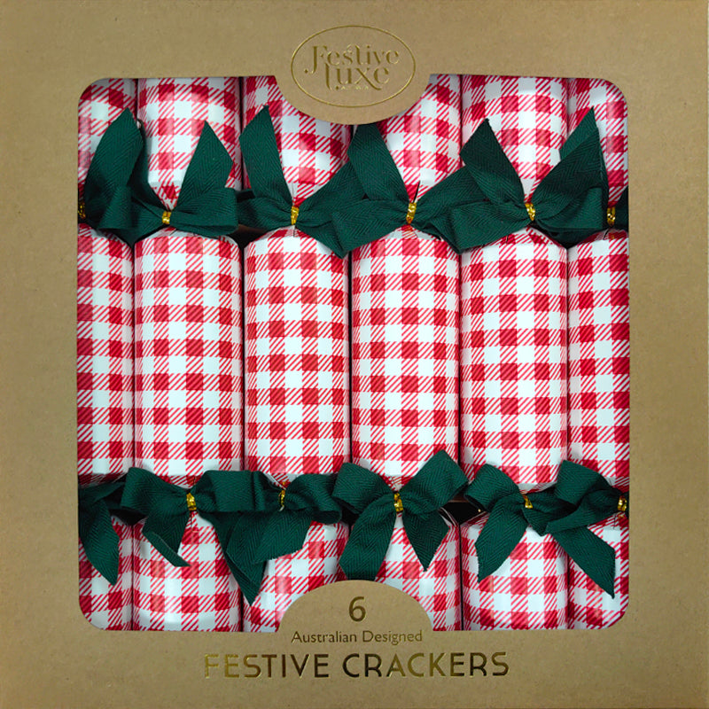 Pack of festive crackers with red and white checkered design and green bows on a brown background.