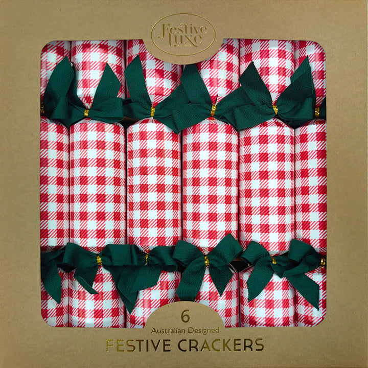 Pack of festive crackers with red and white checkered design and green bows on a brown background.