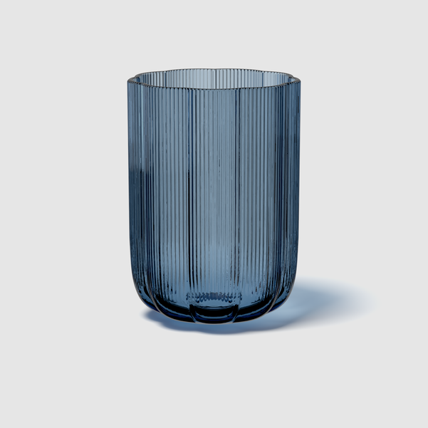 Blue glass vase with ribbed texture on a light gray background