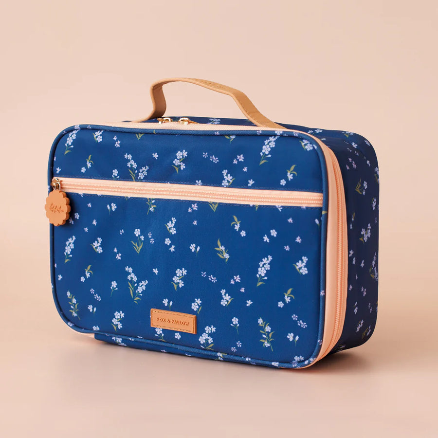 Blue floral-patterned lunch bag with a beige handle on a beige background