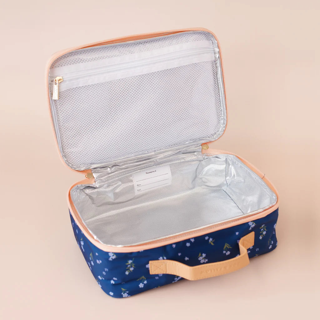 Open blue lunch bag with floral pattern on a beige background