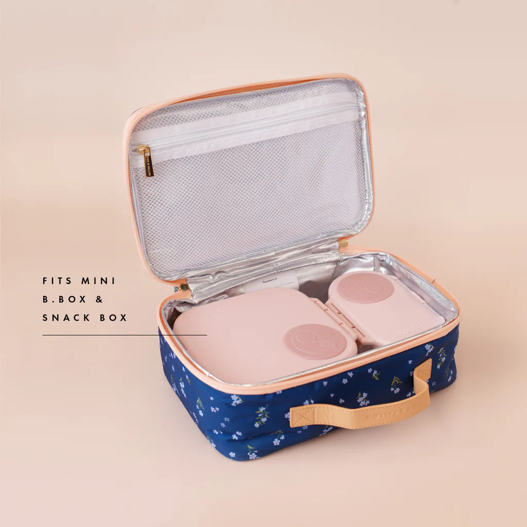 Blue floral-patterned lunch box with pink interior compartments on a beige background