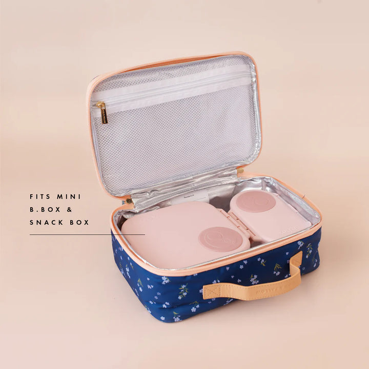Blue floral-patterned lunch box with pink interior compartments on a beige background