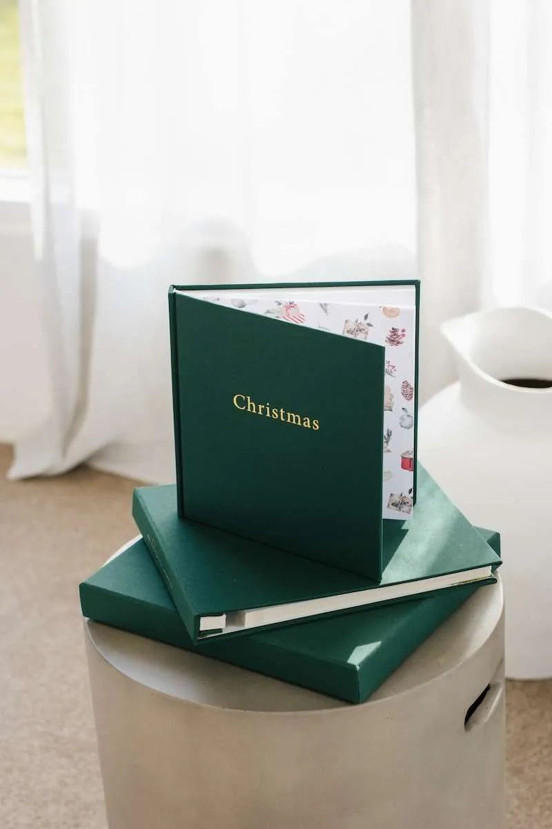 Green Christmas-themed book on a white surface with a blurred background