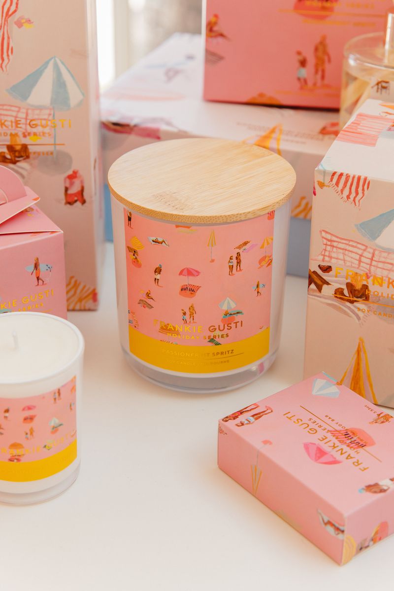 Candle with beach theme label and packaging on a white surface