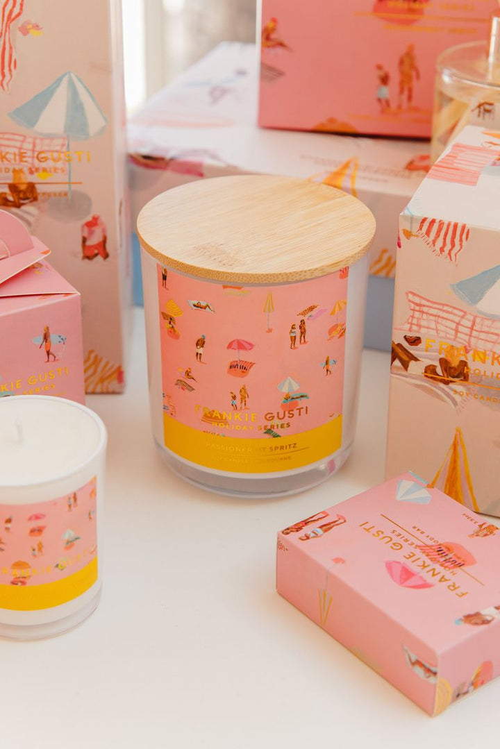 Candle with beach theme label and packaging on a white surface