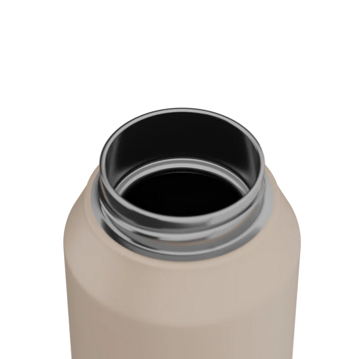 Close-up of a beige water bottle with a black interior on a white background