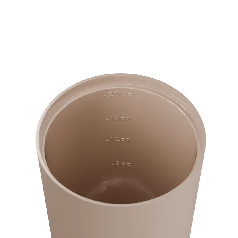 Beige measuring cup with volume markings on a white background