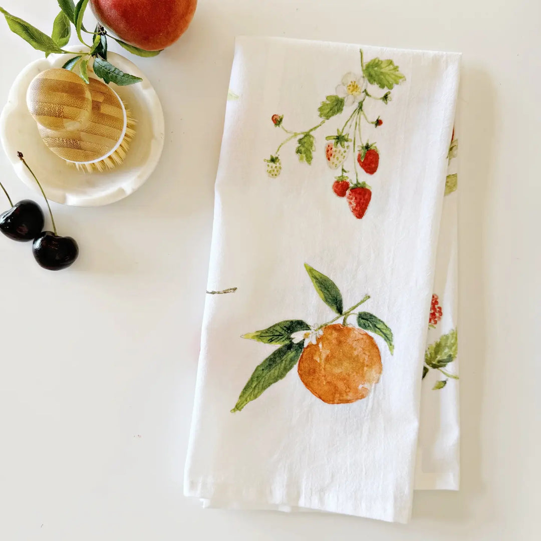 White towel with fruit and strawberry pattern on a white surface