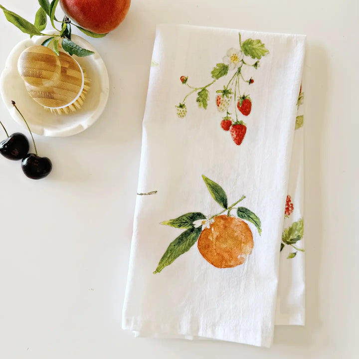 White towel with fruit and strawberry pattern on a white surface