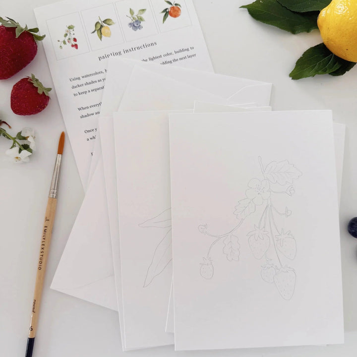 Artistic painting instructions with a brush and fruit on a white surface