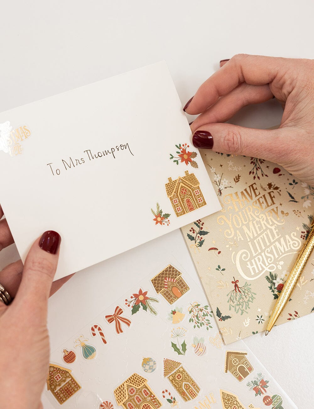 Hands holding a small white card with decorative elements and text.