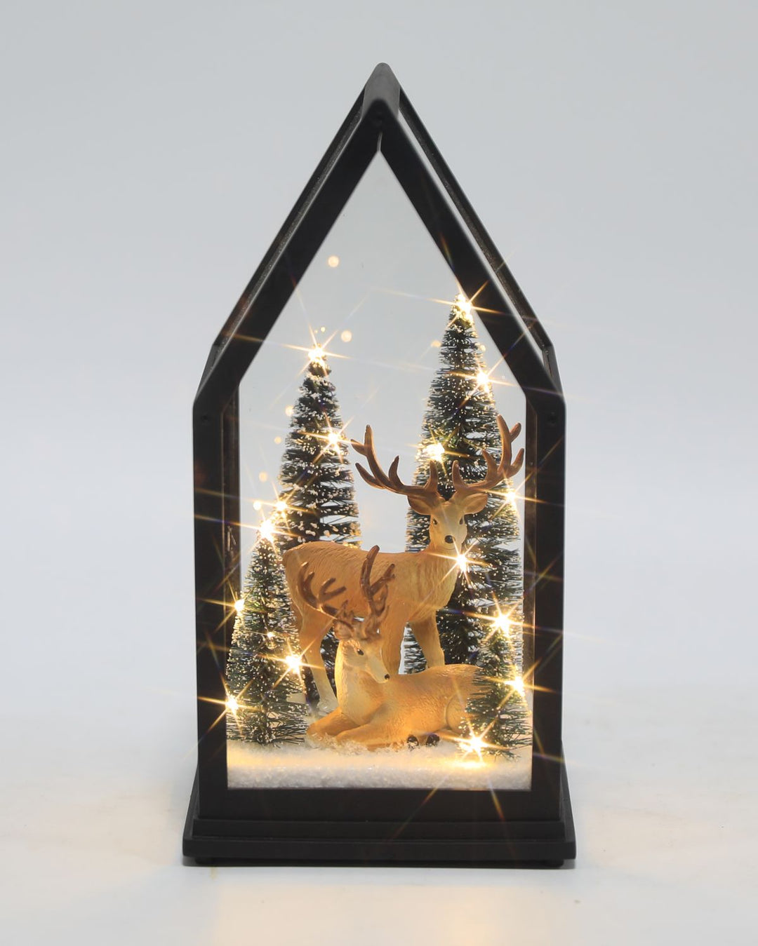 A Christmas light up glass lantern with trees &amp; reindeer.