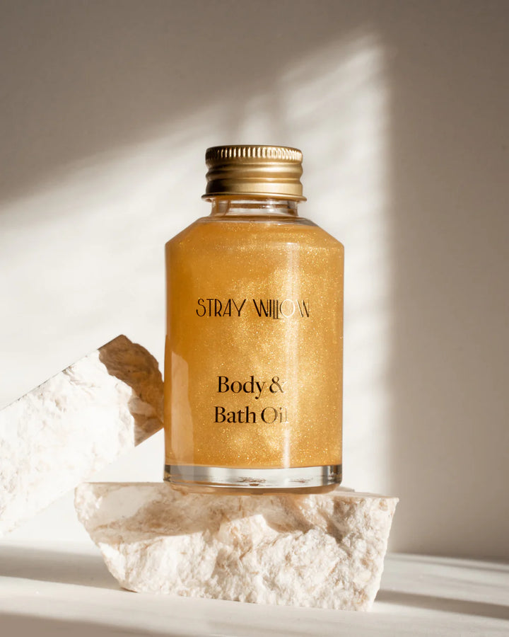 Stray Willow body and bath oil bottle on a stone surface with soft lighting