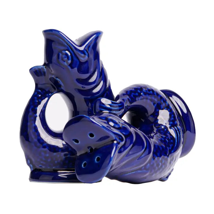 Blue ceramic fish shaped salt &amp; pepper shakers on a white background