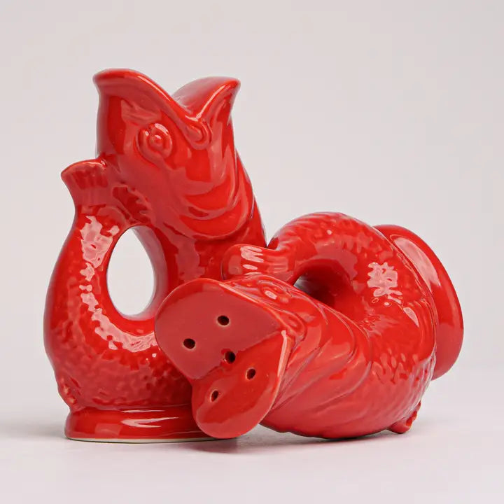 Red ceramic fish-shaped salt and pepper shaker set on a light gray background
