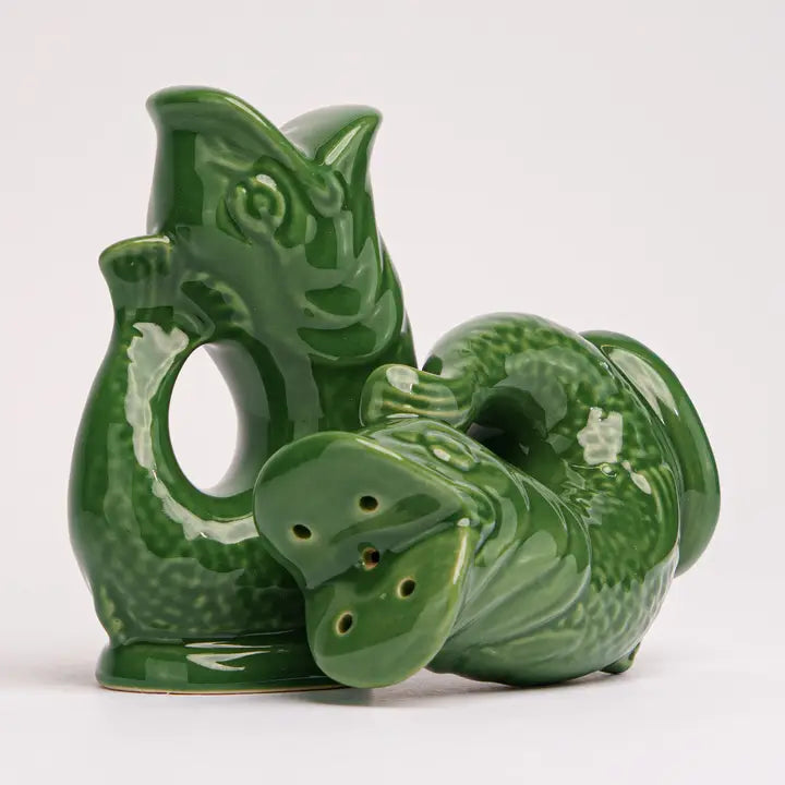 Dark green ceramic fish shaped salt & pepper shakers on a white background