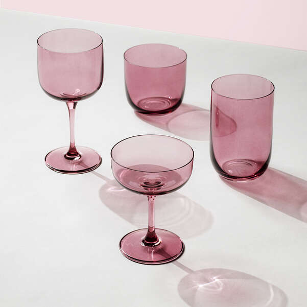 Set of four pink glassware items on a light background